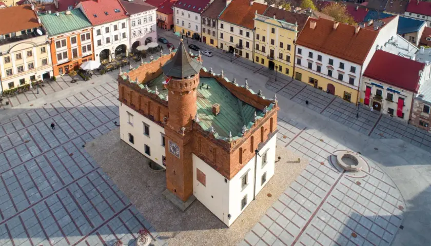 Rynek w Tarnowie, polskim biegunie ciepła, z ratuszem i kolorowymi kamienicami.