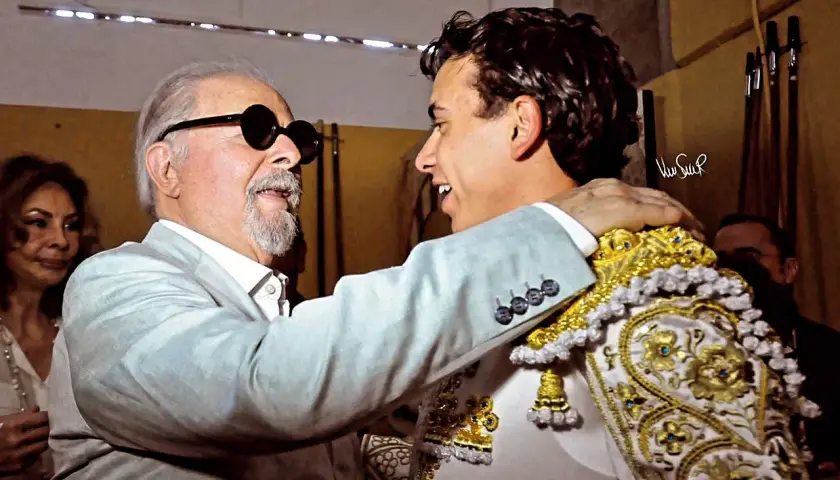 Un hombre mayor con gafas de sol abraza al torero Juan de Castilla, quien luce su traje de luces.