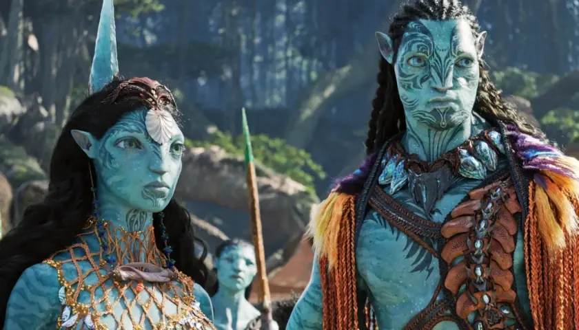Neytiri i Jake w strojach Na'vi, czekają na premierę Avatar 3. Ich twarze zdobią plemienne wzory, a w tle widać fragmenty pandoriańskiego lasu.