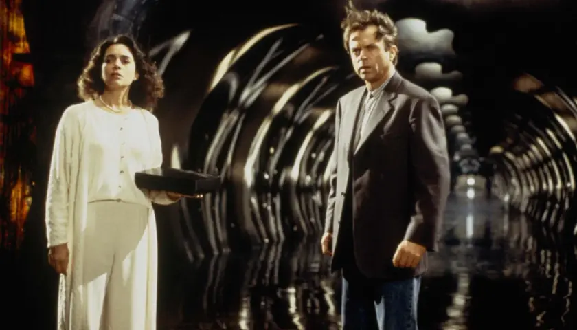 Uomo e donna in un tunnel futuristico. Lei tiene una scatola nera, forse il seme della follia, il cui significato è ancora ignoto.