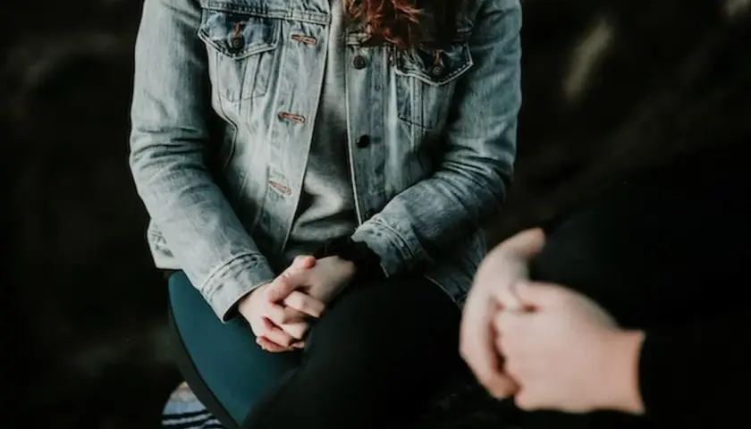 Due persone si tengono per mano, una con una giacca di jeans. Potrebbe essere un momento di conforto per chi soffre di paura del sangue, nome comune per l'emofobia.
