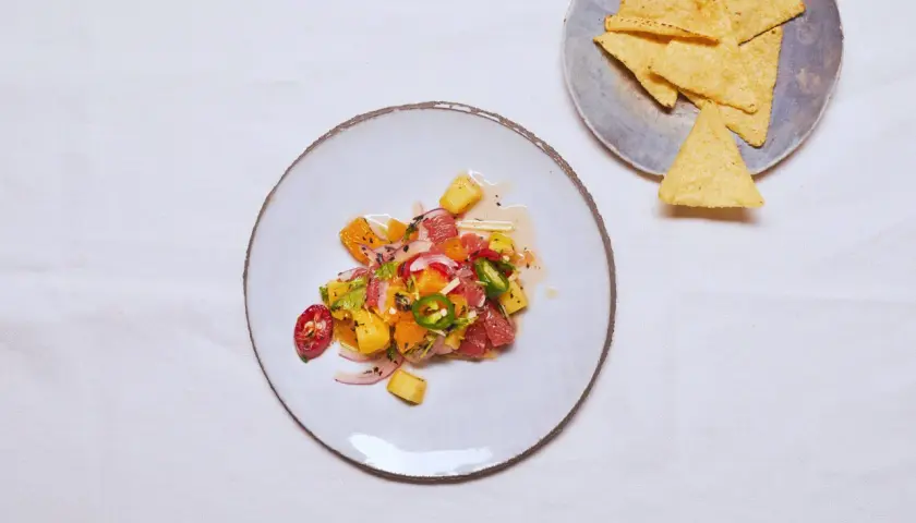Kolorowe ceviche z owocami cytrusowymi, papryczką chili i cebulą, obok nachos.