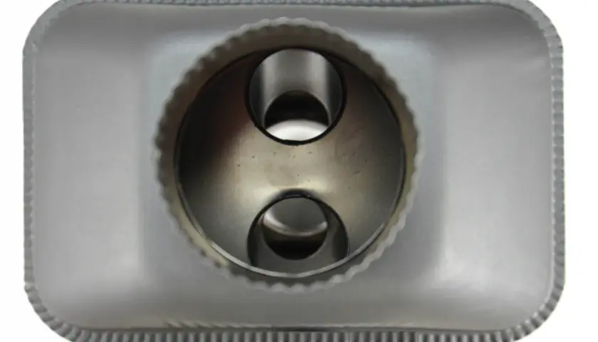 Metalowy radiator do kominka, z dwoma okrągłymi otworami w środku, gotowy do montażu.