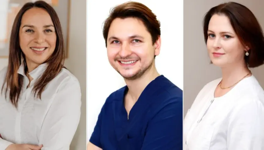 Trzy uśmiechnięte osoby: kobieta w białej koszuli, mężczyzna w granatowym mundurku, kobieta w białej bluzce.