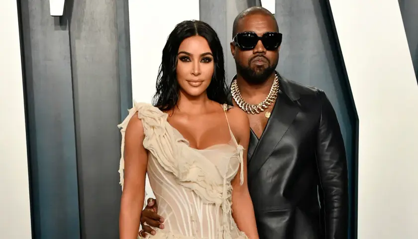 Kim Kardashian i jej mąż, Kanye West, pozują do zdjęć w eleganckich strojach.