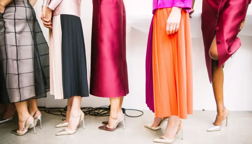 Des robes fluides et plissées, aux couleurs vives et pastel, sont associées à des escarpins élégants. Quelle chaussure avec une robe ? Les talons aiguilles dorés et argentés complètent ces tenues.