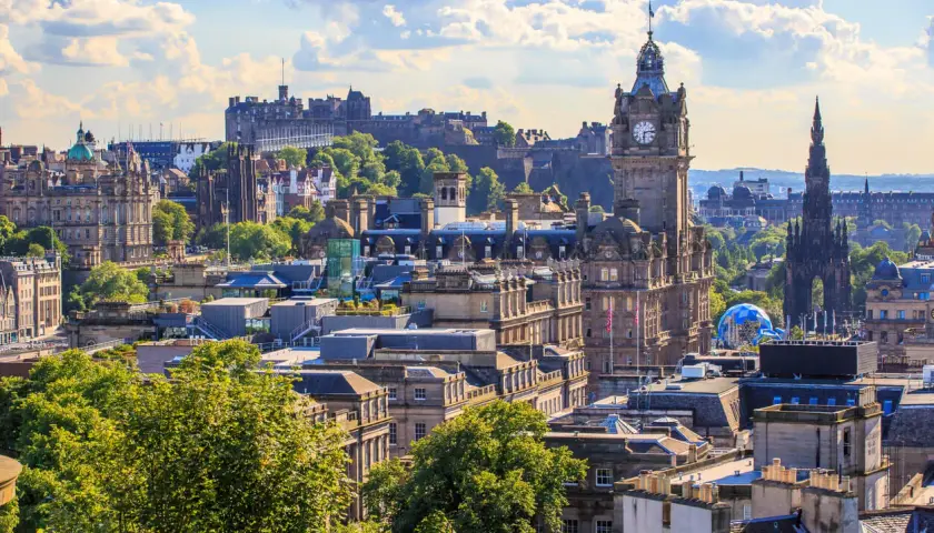 Edinburghs Skyline mit Schloss und Uhrenturm. Die beste Reisezeit für diese Aussicht ist im Sommer, wenn die Bäume grün sind.