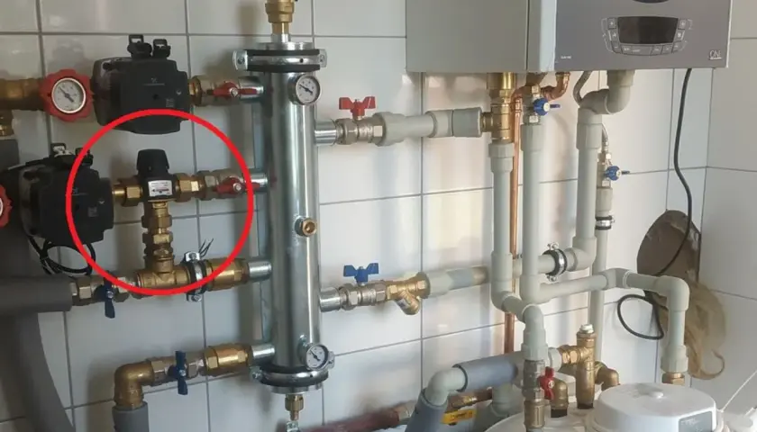 Czerwone kółko zaznacza zawór termostatyczny, kluczowy element systemu grzewczego, który reguluje temperaturę.