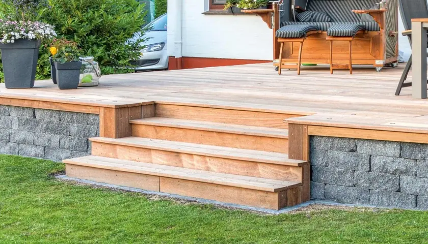 Eine schöne Holztreppe mit 2 Stufen, die man leicht selber bauen kann, führt zur Terrasse.