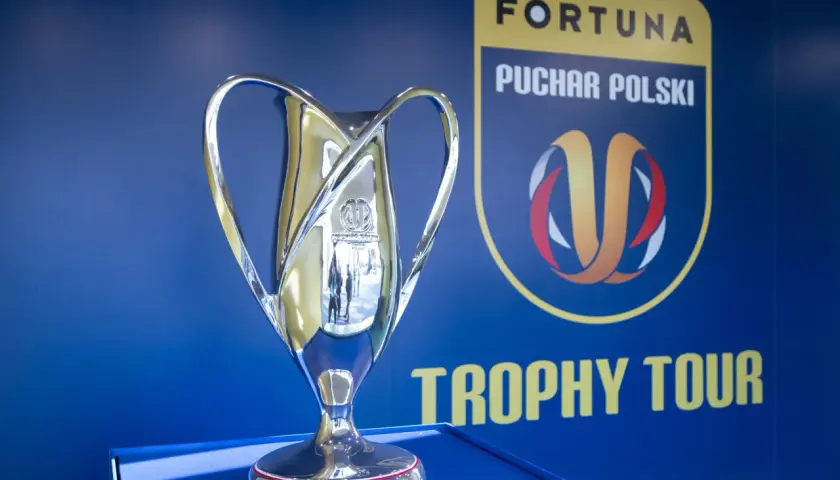 Błyszczący puchar Fortuna Pucharu Polski na tle niebieskiej ściany z logo i napisem "Trophy Tour".