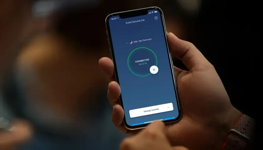 Dłoń trzyma smartfon z aktywnym połączeniem vpn w telefonie, połączonym z serwerem w San Francisco.