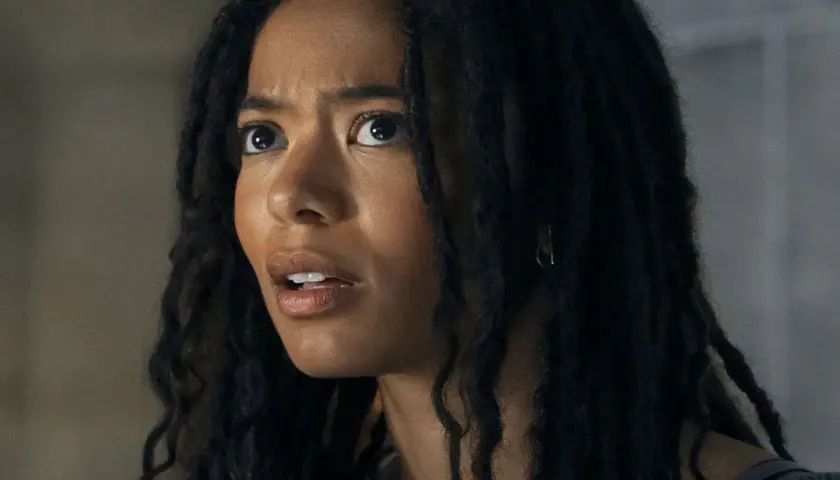 Gros plan sur le visage d'une jeune femme aux dreadlocks, l'air choqué. Elle pourrait être un personnage de gen v saison 3.