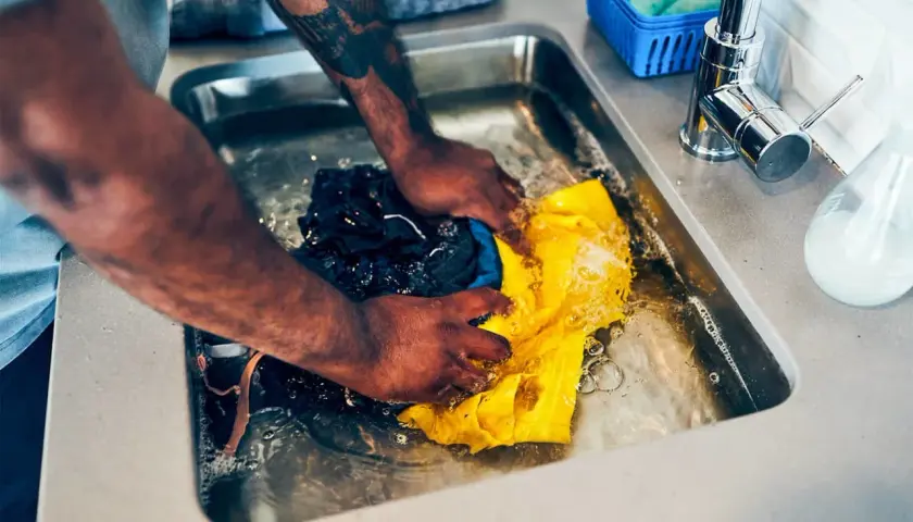 Hände waschen Kleidung im Spülbecken, eine Methode für waschen ohne waschmaschine.