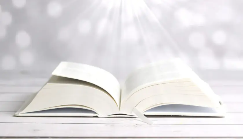 Ein aufgeschlagenes Buch mit einem Lesezeichen, das Lichtstrahlen empfängt. Wie in Phlm 1:3, ein Symbol für Hoffnung und Weisheit.