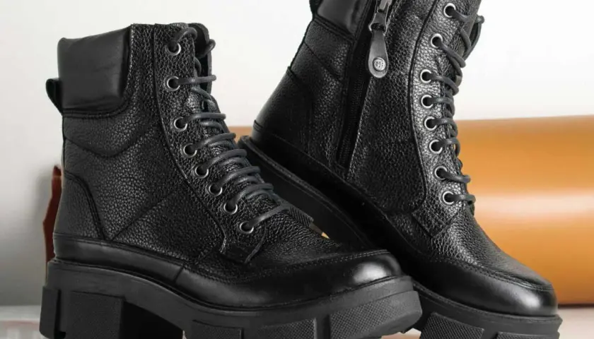 Paire de bottes noires en cuir texturé, parfaites pour un entretien facile. Ces bottes à lacets et fermeture éclair sont prêtes pour toutes vos aventures.
