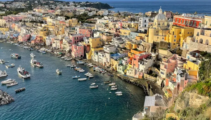 Colorful houses line a harbor filled with boats, a picturesque scene of things to do in Procida.