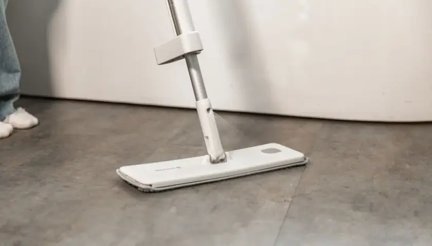 Mopa moderna rociando agua para fregar el suelo.
