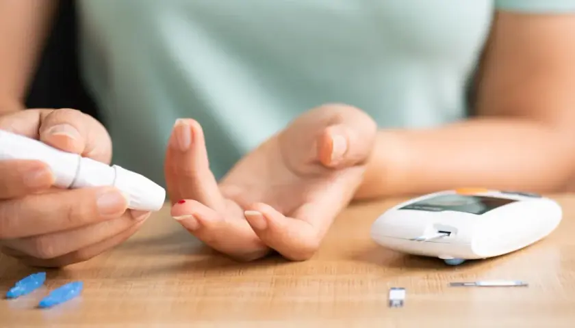 Osoba mierzy poziom cukru we krwi glukometrem. Czy cukrzyca jest dziedziczna? To pytanie nurtuje wiele osób, zwłaszcza gdy w rodzinie występowały przypadki tej choroby.