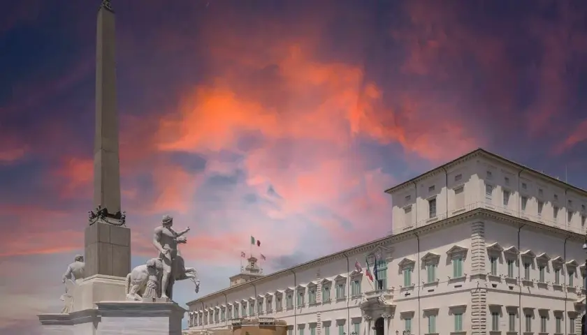 Il Quirinale, Colle Romano, con obelisco e scultura equestre sotto un cielo infuocato.