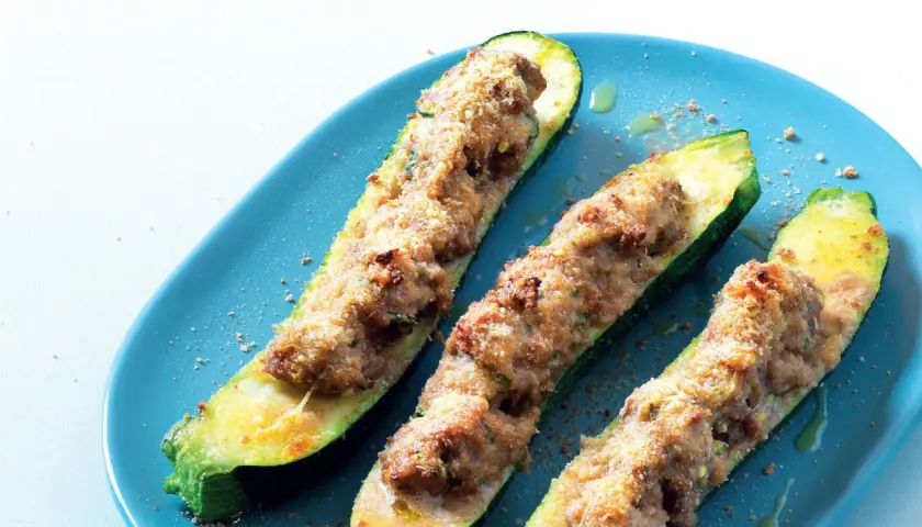 Zucchine ripiene velocissime, dorate e croccanti, servite su un piatto blu. Un piatto semplice e gustoso.
