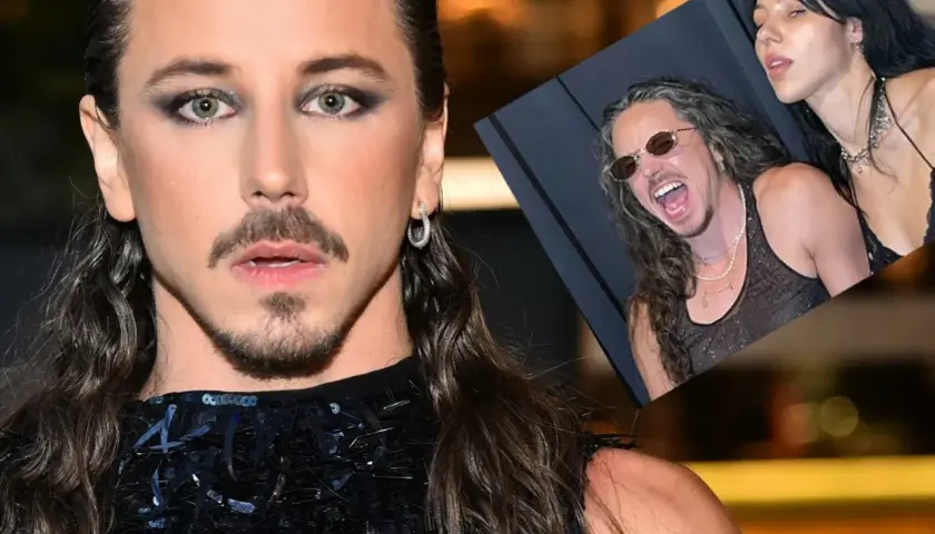 Michał Szpak z żoną, uśmiechnięty i w okularach, na zdjęciu w tle.