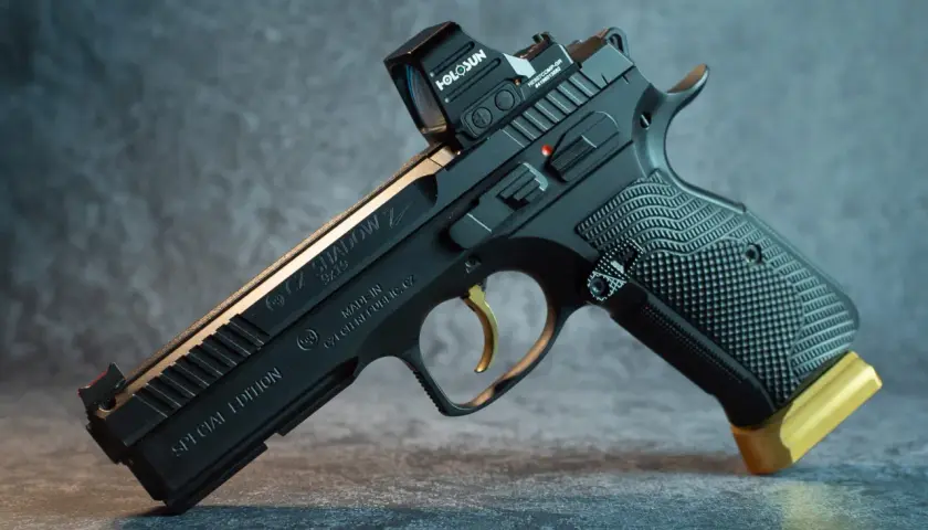 Czarny pistolet CZ Shadow 2 Special Edition z celownikiem Holosun i złotym przedłużeniem magazynka. Ten pistolet sygnałowy to marzenie kolekcjonera.