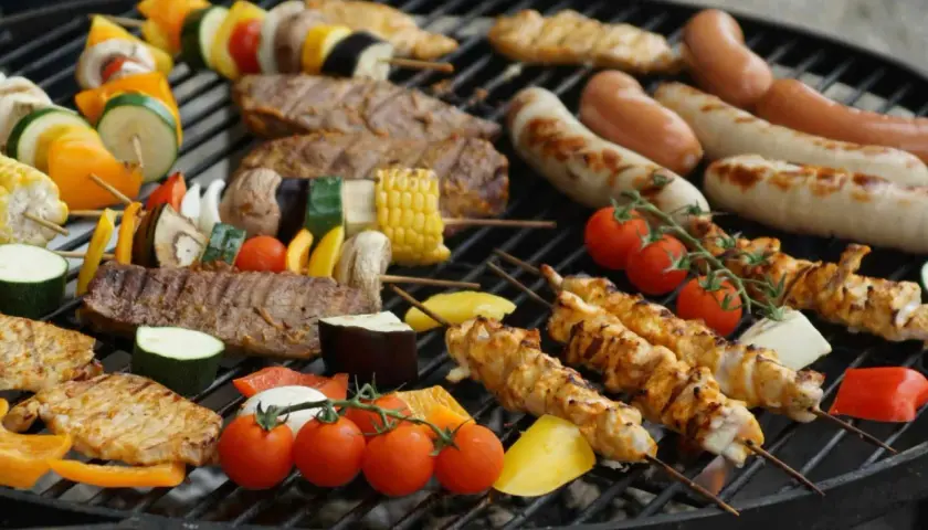 Brochettes de poulet, saucisses, steaks et légumes colorés, une belle variété de viande à faire au barbecue pour un repas convivial.