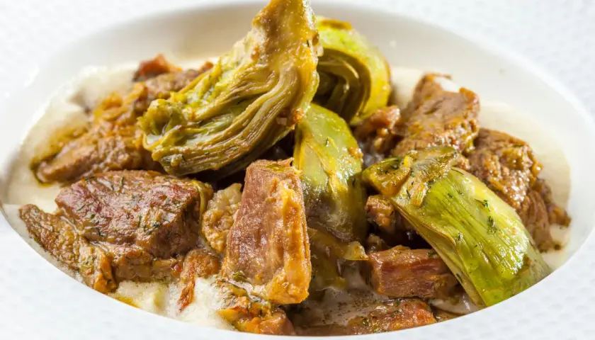 Un saporito agnello con carciofi in umido, un piatto tradizionale che profuma di casa.