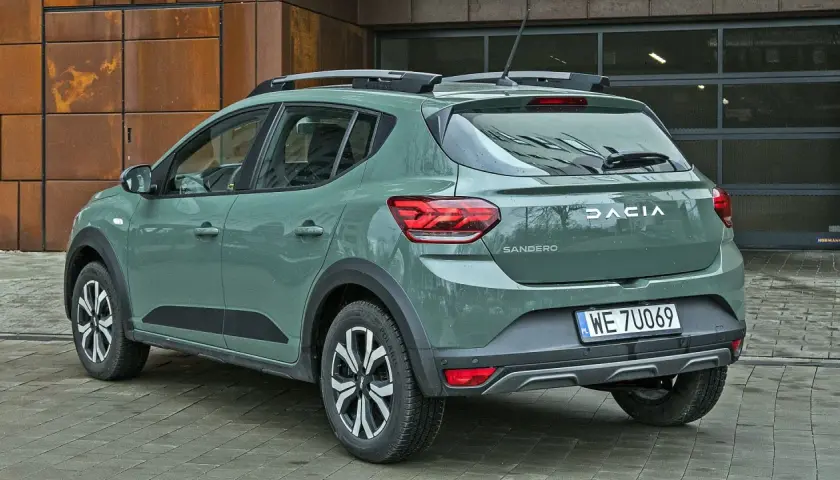 Dacia Sandero w zielonym kolorze lakieru, z relingami dachowymi, prezentuje się nowocześnie.