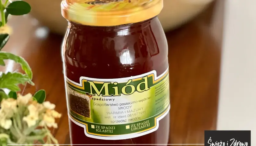 Słoik ciemnego miodu spadziowego liściastego, z etykietą "Miód spadziowy", podkreślającą jego właściwości.