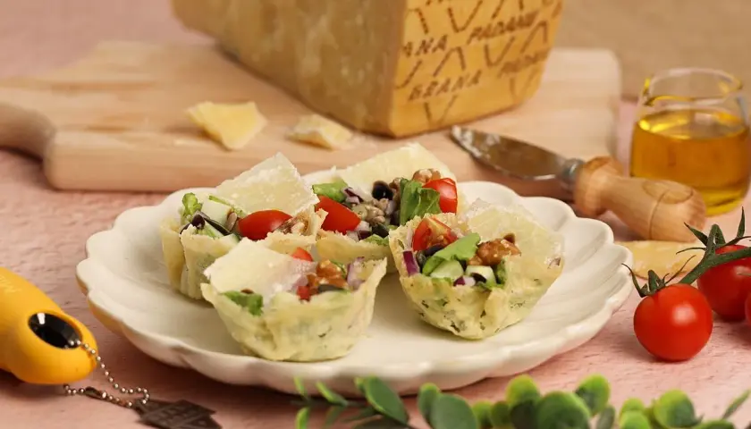 Cestas crujientes de queso **Grana Padano DOP** rellenas de ensalada fresca, tomates y nueces.
