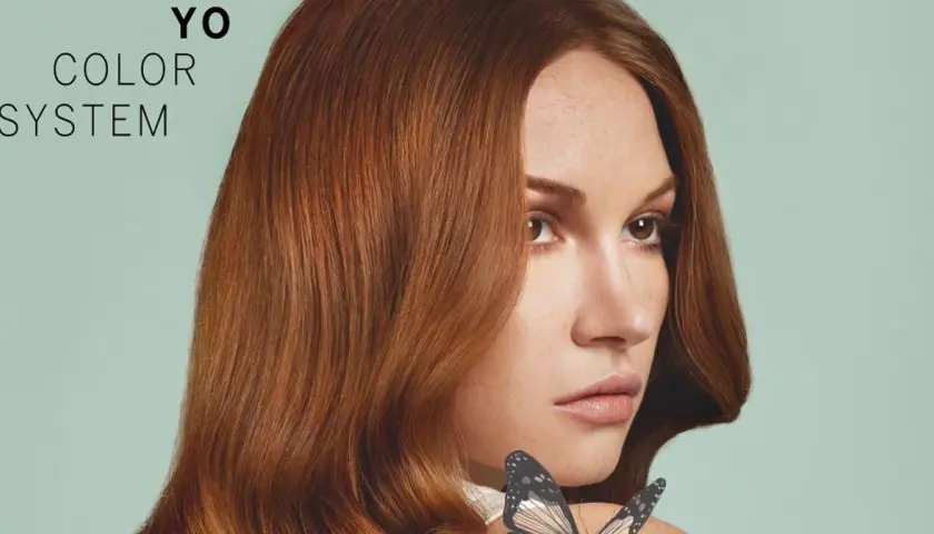 Kobieta z rudymi włosami i motylem na ramieniu, tekst "YO COLOR SYSTEM".