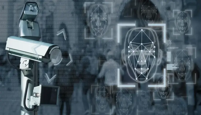 Caméra de surveillance avec analyse faciale. Des visages numérisés apparaissent sur fond de code binaire.