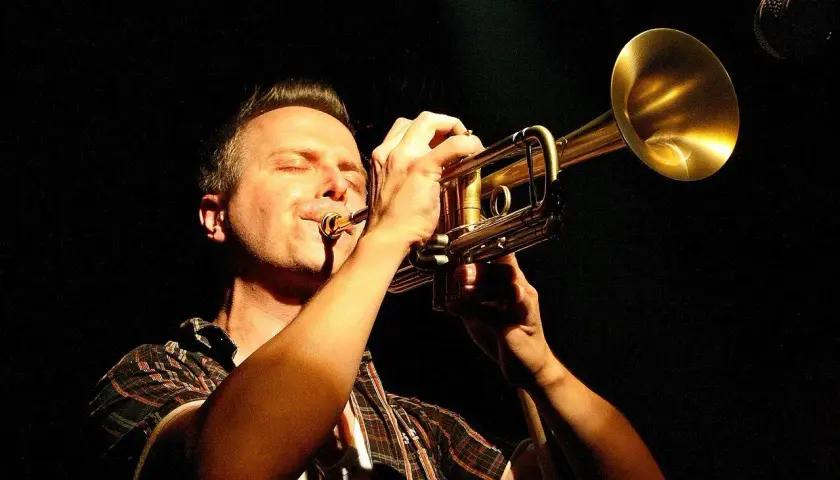 Muzyk z zamkniętymi oczami gra na trąbce, tworząc magiczny ep.