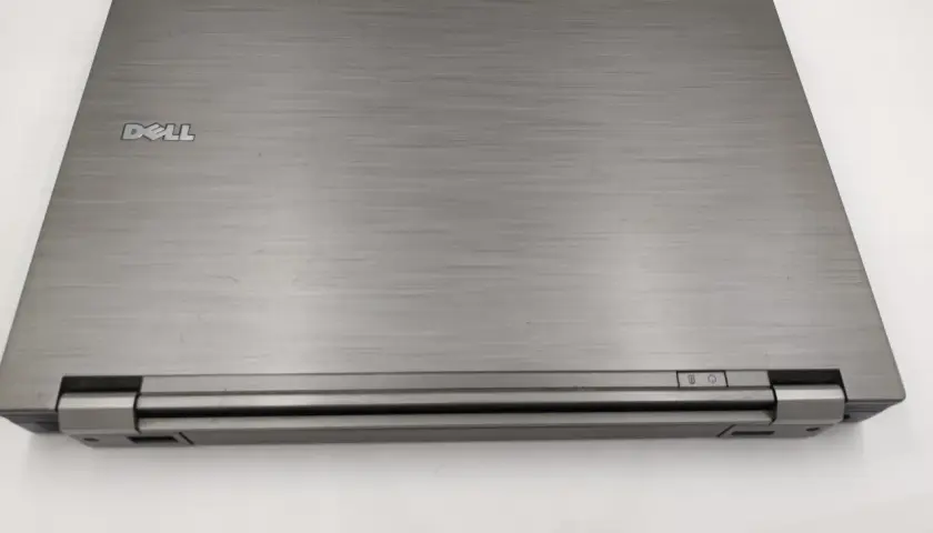 Zamknięty laptop Dell Latitude E6410, z widocznym logo Dell i przyciskami zasilania. Idealny do sprawdzenia dell latitude e6410 specyfikacja.