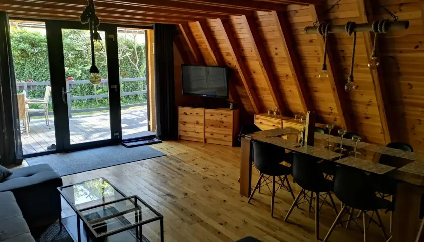 Przytulne domki nad morzem 50 m od plaży. Drewniane wnętrze z salonem, jadalnią i widokiem na ogród. Idealne miejsce na relaks.
