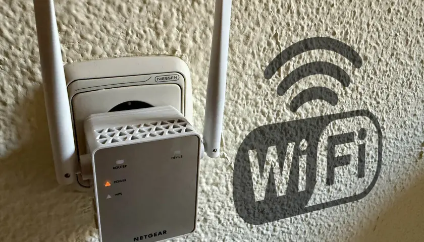 Extensor de red **wireless WAN** enchufado a la pared, con un símbolo de Wi-Fi al lado.