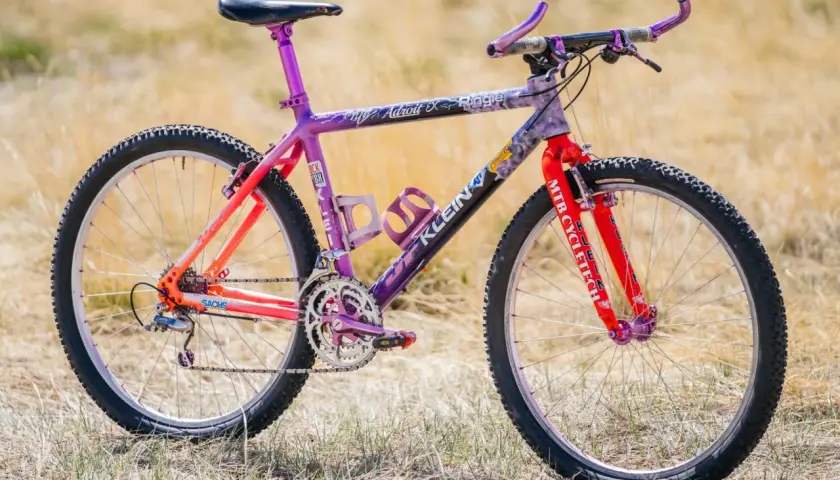 A vibrant Klein Adroit mountain bike with purple and orange fade paint, ready for an adventure.