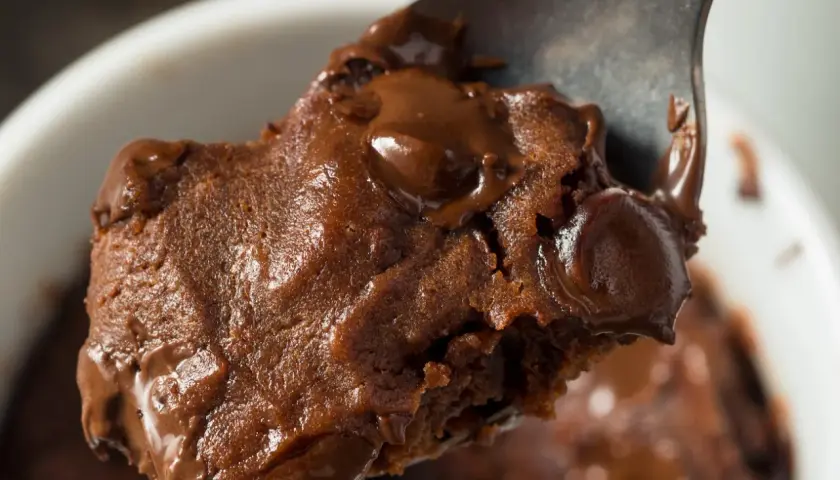 Łyżka z porcją pysznej, pieczonej owsianki brownie z roztopioną czekoladą.