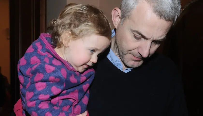 Hubert Urbański z córką, która przytula się do niego w bluzie w serduszka.
