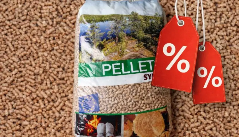 Worek pelletu Sylva Pomorskie na tle drobnych ziarenek. Dwa czerwone kupony z procentami sugerują promocję.