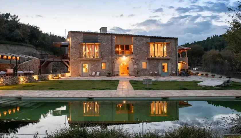 Casa rural en Pinell de Solsonès, con piscina y reflejos de luces cálidas.