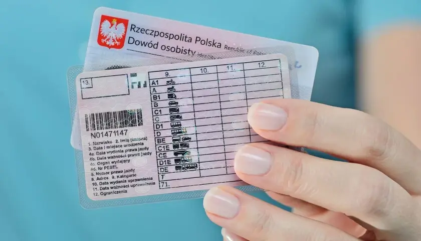 Dłoń trzyma polskie prawo jazdy, widoczna jest data ważności uprawnienia.