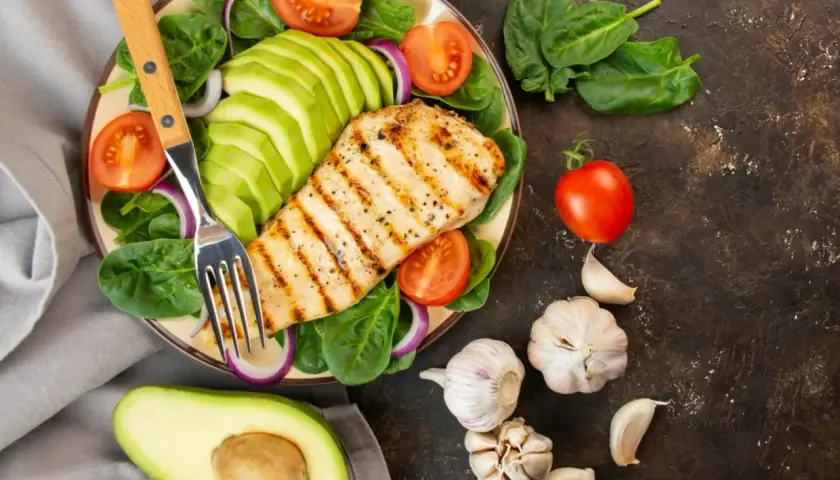 Pechuga de pollo a la parrilla con aguacate, espinacas y tomate. Ideal para una dieta antiinflamatoria menopausia.