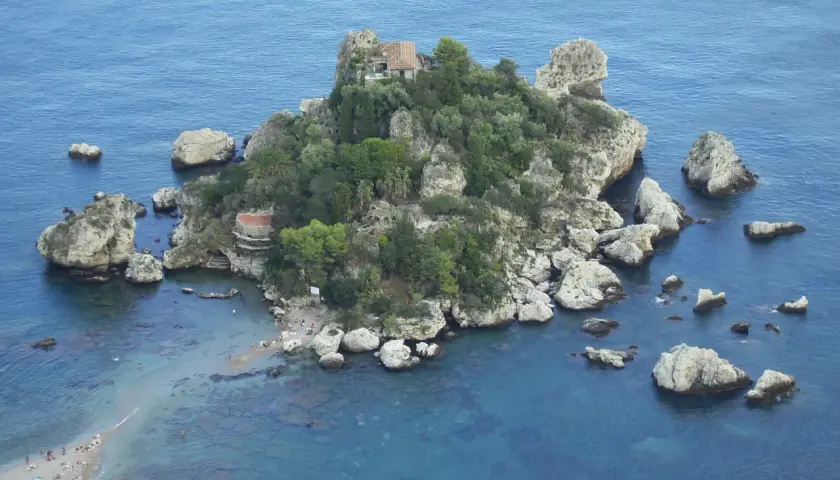 Isola Bella, una perla tra le spiagge della Sicilia orientale, con scogli e vegetazione lussureggiante.