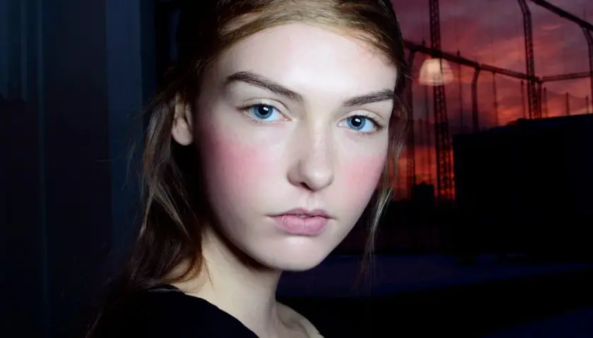 Ragazza con blush rosato sulle guance, un esempio di come scegliere il colore del blush per un look naturale.