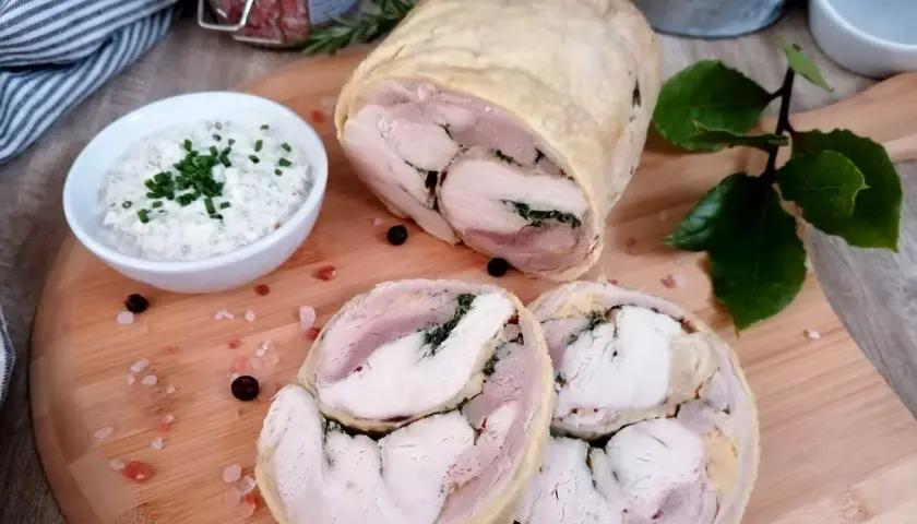 Galantyna z kurczaka, soczysta i aromatyczna, podana z kremowym sosem. Idealna na uroczysty obiad.