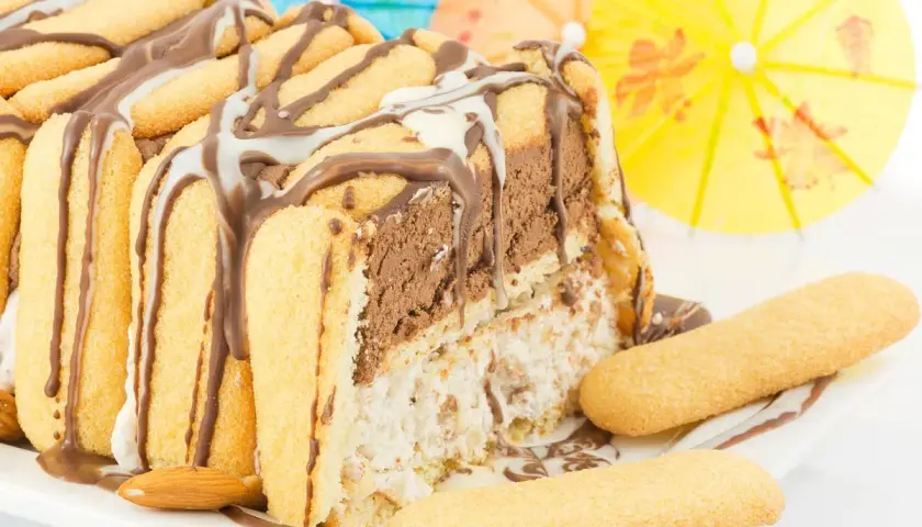 Delizioso zuccotto gelato, un tripudio di cioccolato e crema, decorato con savoiardi e mandorle. Perfetto per un'estate golosa!