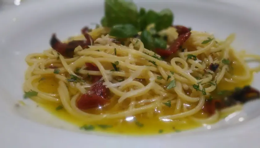 Spaghetti alla carrettiera conditi con pomodori secchi, aglio, peperoncino e basilico fresco, un piatto semplice ma gustoso.