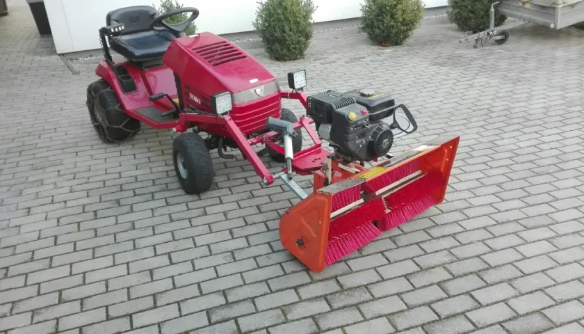 Selbstgebaute Kehrmaschine mit Toro-Aufsitzmäher, Motor und breiter Bürste. Perfekt für den Winterdienst!